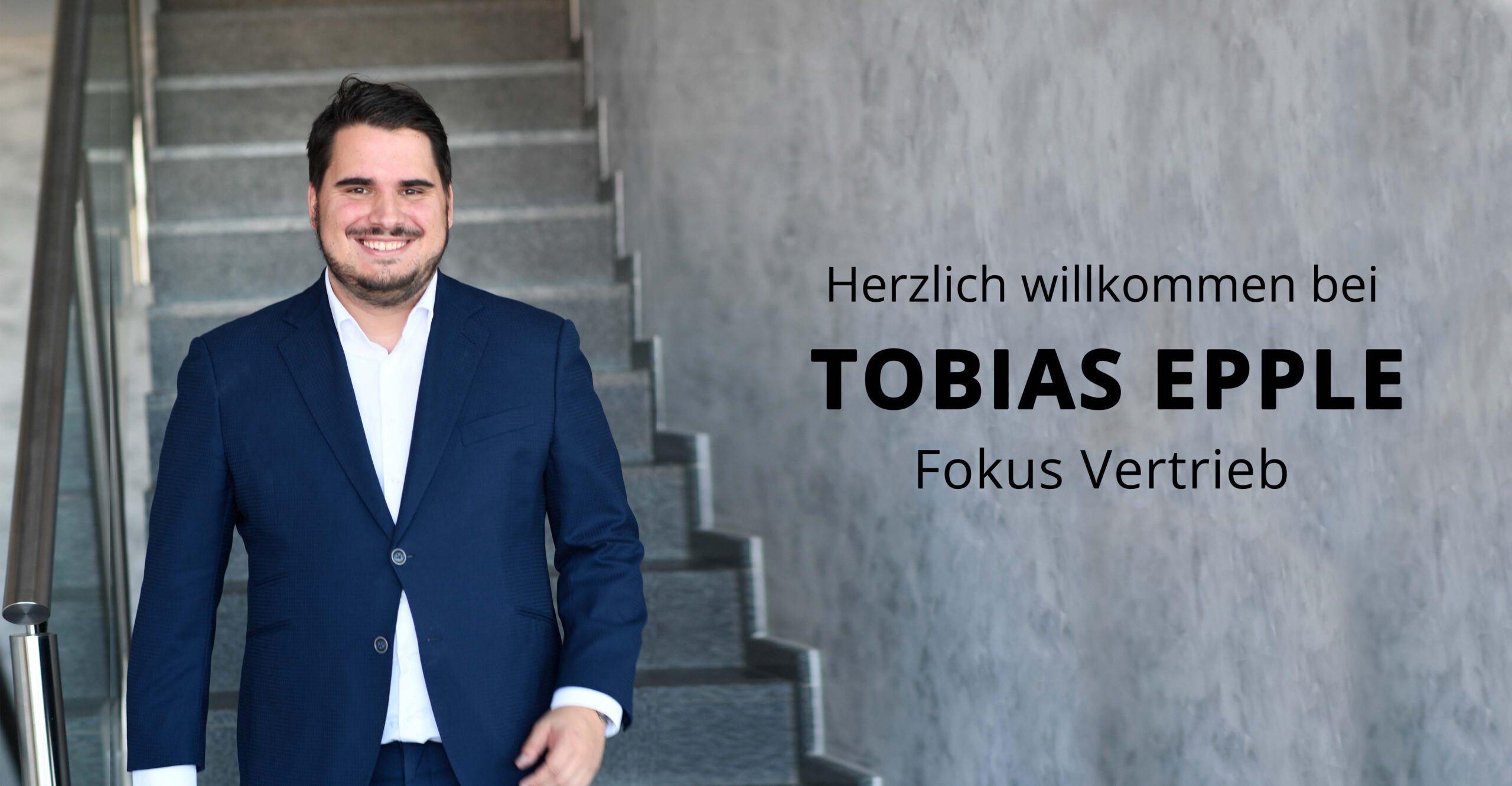 Der Autor und Keynote Speaker für Führung und Vertrieb Tobias Epple lächelnd am Fuße einer Treppe